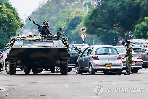 (하라레 AFP=연합뉴스) 15일(현지시간) 쿠데타가 일어난 짐바브웨 수도 하라레에서 장갑차를 동원한 군인들이 교차로를 장악, 교통을 통제하고 있다. 남아프리카공화국은 이날 성명을 통해 로버트 무가베 짐바브웨 대통령이 제이컵 주마 남아공 대통령과의 전화 통화에서 "자택에 갇혀 있지만 신변에 이상은 없다"고 말했다고 밝혔다.      ymarshal@yna.co.kr