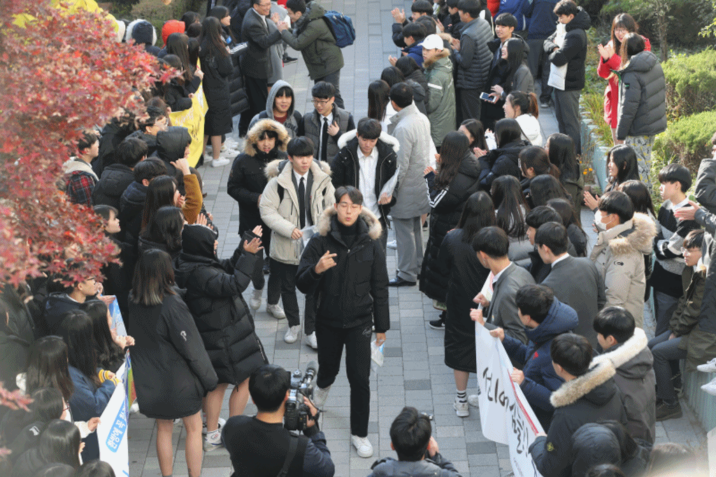수험표를 받은 서울 서초고 3학년 남학생들이 후배들의 응원을 받으며 걸어가고 있다. 신인섭 기자