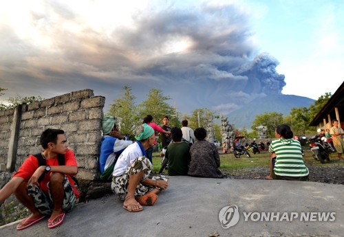 연기 뿜는 화산 바라보는 발리 주민들 (자카르타=연합뉴스) 황철환 특파원 = 26일 인도네시아 발리 섬 카랑아셈 리젠시 주민들이 검은 연기를 뿜어내는 아궁 화산을 걱정스런 얼굴로 바라보고 있다. 2017.11.26 [AFP=연합뉴스]