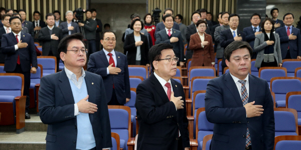 자유한국당 정우택 원내대표, 김광림 정책위의장(앞줄 왼쪽부터) 등 당 소속 의원들이 지난 2일 국회 의원총회에서 국민의례를 하고 있다.  연합뉴스