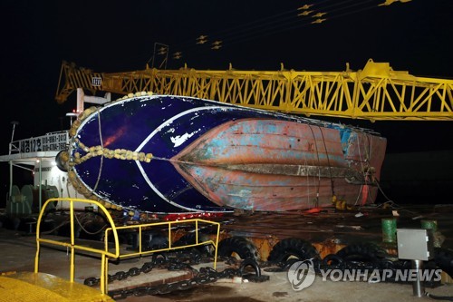 해경 전용부두로 예인된 선창1호 (인천=연합뉴스) 윤태현 기자 = 4일 오전 인천시 중구 인천해양경찰서 전용부두에 낚싯배 선창1호가 예인선에 실린 채 정박해 있다. 선창1호는 전날 오전 영흥면 영흥대교 인근 해상에서 급유선과 충돌해 전복됐다. 이 사고로 승선원 22명 중 13명이 숨지고 2명이 실종됐다. 2017.12.4      tomatoyoon@yna.co.kr