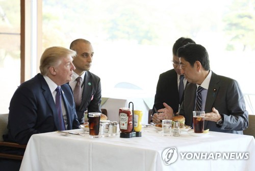 도쿄 먼치스 버거 매장에서 점심식사하는 아베 총리와 트럼프 [AP=연합뉴스]