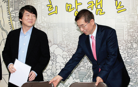 2011년 서울시장 보궐선거 출마를 선언한 박원순 무소속 후보가 자신의 선거캠프를 찾은 안철수 서울대 교수에게 자리를 권하고 있다. [중앙포토]