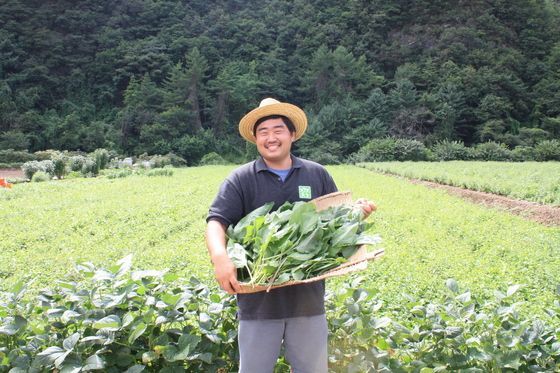 재배한 곤드레를 들고 활짝 웃는 청년 농부 박상봉 씨.