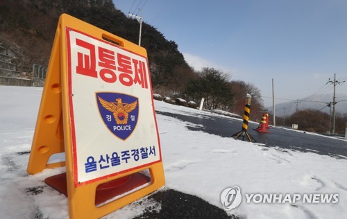 설원으로 변한 도로 통제 (울산=연합뉴스) 김용태 기자 = 10일 오전 울산시 울주군 상북면 일대에 한때 많은 눈이 내린 가운데 경찰이 배내골 인근 도로를 통제하고 있다. 2018.1.10      yongtae@yna.co.kr