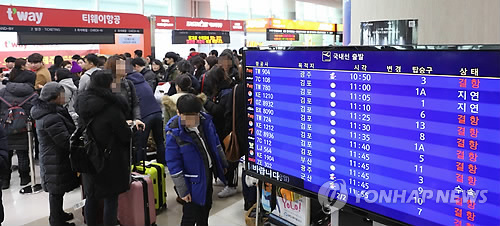 결항 안내 가득한 제주공항 전광판 (제주=연합뉴스) 김호천 기자 = 11일 제주공항에 강풍을 동반한 폭설이 내리면서 항공편이 무더기로 결항했다. 결항 안내가 가득한 전광판 뒤로 관광객들이 항공권을 구하기 위해 줄을 서서 기다리고 있다. 2018.1.11      khc@yna.co.kr
