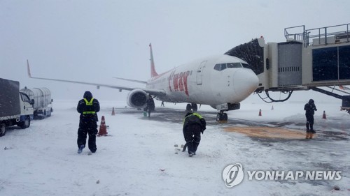 제주공항 계류장 제설작업 (제주=연합뉴스) 김호천 기자 = 11일 오전 제주국제공항 계류장에서 공항공사와 항공사 직원들이 제설작업을 벌이고 있다. 2018.1.11 [독자 제공=연합뉴스]      khc@yna.co.kr
