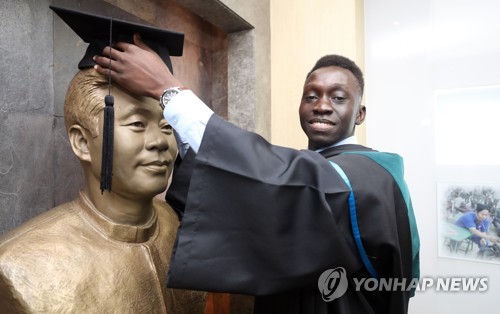 이태석 신부에게 헌정하는 학사모 (부산=연합뉴스) 김재홍 기자 = 15일 오후 부산 부산진구 인제대 의과대학 1층 강당에서 열린 제34회 부산 인제의대 학위수여식에 참석한 아프리카 남수단 톤즈 출신 유학생 토마스 타반 아콧(33) 씨가 강당 옆 이태석 신부 기념실을 찾아 이 신부의 동상 위에 학사모를 씌우고 있다. 이 신부의 주선으로 한국에 온 토마스 씨는 이날 인제대 의대를 졸업했다. 그는 훌륭한 외과 전문의가 돼 남수단으로 돌아가는 것이 목표다. 2018.1.15      pitbull@yna.co.kr
