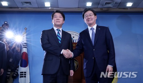 【서울=뉴시스】홍효식 기자 = 국민의당 안철수(왼쪽), 바른정당 유승민 대표가 18일 오전 서울 여의도 국회 정론관에서 공동 통합 선언을 마친 뒤 악수하고 있다. 2018.01.18. yesphoto@newsis.com