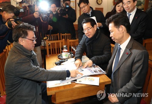 '신문에서 봤어요!' (서울=연합뉴스) 김주형 기자 = 홍장표 청와대 경제수석(오른쪽)과 김영록 농림축산식품부 장관(오른쪽 두 번째)이 19일 오전 저임금 인상의 필요성과 일자리 안정자금 등의 홍보를 위해 서울 중구 신당동 식당가를 방문해 상인들과 대화를 나누던 중 식당 대표가 지난 18일 상점가를 방문했던 장하성 정책실장의 신문기사를 보여주고 있다. 2018.1.19