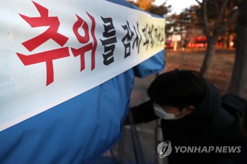 피하고 싶은 한파 (광주=연합뉴스) 정회성 기자 = 광주와 전남 지역에 한파주의보가 내려진 24일 오전 광주 서구 치평동 한 버스정류장에서 시민이 바람막이용 온기텐트에 들어가고 있다. 2018.1.24