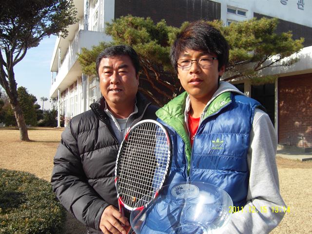 정현(당시 15살)이 2011년 오렌지보울 국제 주니어테니스대회 16세부 남자 단식우승을 차지한 뒤 아버지 정석진(왼쪽)씨와 함께 수원 삼일공고에서 우승컵을 들고 포즈를 취하고 있다. 한국일보 자료사진