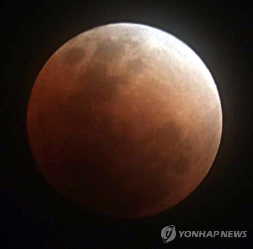 붉게 물든 달 (과천=연합뉴스) 권준우 기자 = 슈퍼 문과 블루문, 블러드문 현상이 한 번에 일어난 31일 오후 경기도 과천시 국립과천과학관 앞에서 보이는 달이 개기월식을 마치고 점차 붉게 물들고 있다.