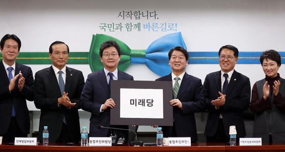 안철수 국민의당 대표와 유승민 바른정당 대표가 2일 오후 서울 여의도 국회의원회관에서 열린 통합추진위원회 제3차 전체회의에서 통합신당 최종 당명으로 '미래당'을 선정, 문구를 들어보이고 있다. 왼쪽부터 이동섭, 김중로 국민의당 의원, 유 대표, 안 대표, 정운천 바른정당 최고위원, 이언주 국민의당 의원.(바른정당 제공) 2018.2.2/뉴스1