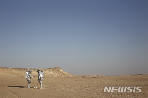【도파르=AP/뉴시스】 아라비아 반도 남부 오만의 도파르 사막에서 7일 두 과학자가 장래 화성 탐사 때 사용될 우주복과 지질 레이다를 실험하고 있다. 화성과 닮은 이 사막에서 25개국 200여 과학자들이 4주 동안 화성 유인 탐사 관련 기술을 실외 테스트하는 중이다. 2018. 2. 8.