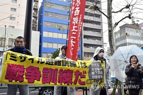 일본 도쿄에서 지난 1월 열린 '北미사일 발사' 가정 첫 대피 훈련 당시 '전쟁훈련'이라며 반대 집회를 연 시민들. [EPA=연합뉴스 자료사진]