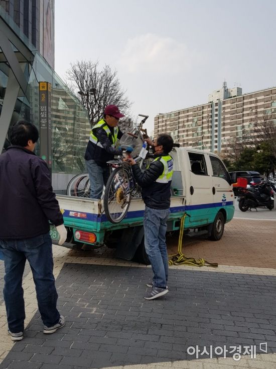 지난 13일 오후 송파구 관계자들이 서울 지하철 2·8호선 잠실역 3번 출구 앞에 방치된 자전거들을 수거하고 있다. (사진=금보령 기자)
