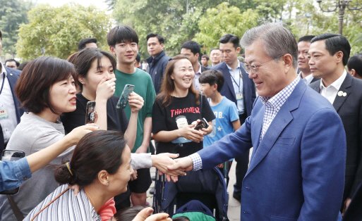 베트남을 국빈 방문중인 문재인 대통령이 아침식사를 하기 위해 24일 베트남 전통 3대 쌀국수집 중의 하나인 포10리쿠옥쓰 식당을 찾아  마주친 현지 교민들과 인사를 하고 있다.(사진=연합뉴스)