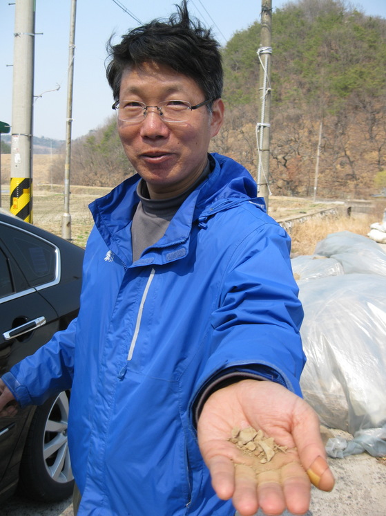 한 관진주광객이 운석 낙하지점의 흙을 모아 손으로 보여 주고 있다. 송봉근 기자