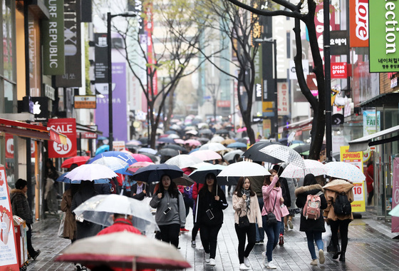 5일 서울 명동거리에서 외국인관광객들이 우산을 쓴 채 걷고 있다. 2018.4.5/사진=뉴스1