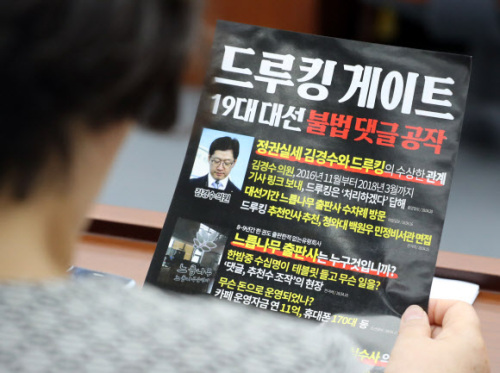 바른미래당 이혜훈 의원이 24일 국회에서 열린 제13차 의원총회에서 `드루킹 게이트`라고 인쇄된 홍보물을 살피고 있다. 연합뉴스