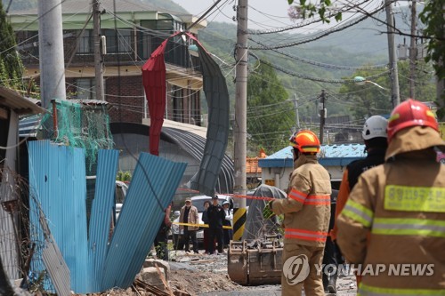 전선에 걸린 지붕 패널  (양주=연합뉴스) 임병식 기자 = 7일 경기도 양주시 봉양동의 가스 폭발 추정 사고 현장에서 소방당국이 수색 작업을 벌이고 있다. 2018.5.7  andphotodo@yna.co.kr  (끝)