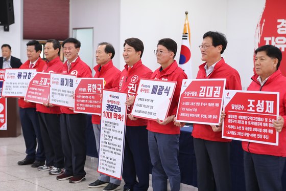 6·13 지방선거에 출마하는 자유한국당 대구 광역·기초단체장 예비후보들이 지난 21일 오후 대구 수성구 범어동 대구시당에서 열린 합동 공약발표회에 참석해 공약을 적은 피켓을 들고 필승을 다짐하고 있다. [뉴스1]