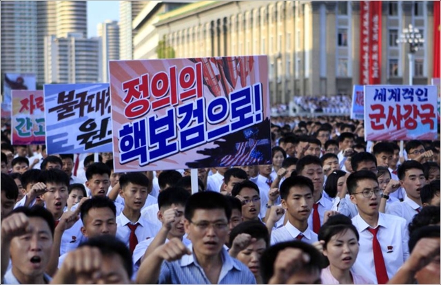 지난해 개최된 평양시 군중집회에서 참가자들이 '정의의 핵보검으로!' 문구가 적힌 플랜카드를 들고 행진하고 있다. ⓒ조선중앙통신