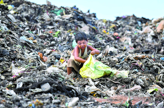 환경의 날을 하루 앞둔 4일 인도 북동부 구와하티시 쓰레기 처분장에서 한 소년이 땔감을 줍고 있다. [AFP=연합뉴스]