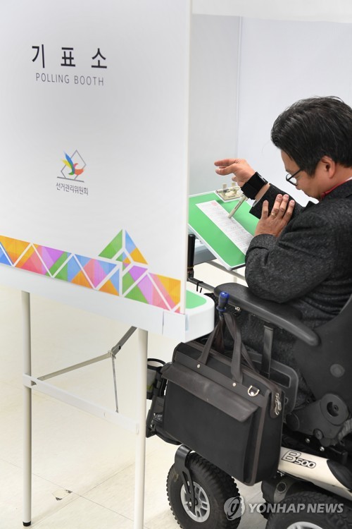 선관위, 장애인용 기표대 공개 (서울=연합뉴스) 이재희 기자 = 23일 서울 종로구 서울특별시선거관리위원회에서 오는 6.13 전국동시지방선거를 앞두고 열린 장애인 투표자 모의체험 행사에서 한 지체장애인이 일반 기표대보다 넓게 제작된 기표대에서 손목에 보조기구를 착용하고 투표를 시연하고 있다. 2018.4.23      scape@yna.co.kr
