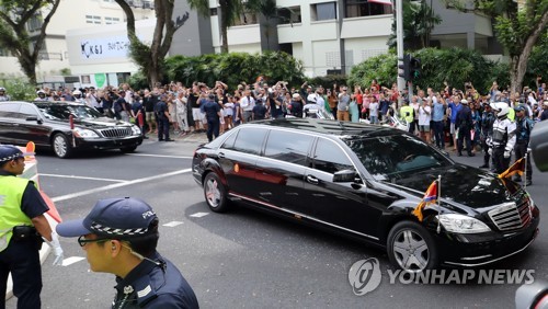 김정은이 궁금한 싱가포르 사람들 (싱가포르=연합뉴스) 한상균 기자 = 북미정상회담을 이틀 앞둔 10일 오후 싱가포르 세인트 리지스 호텔 앞에서 시민들이 김정은 국방위원장이 탄 것으로 보이는 차량을 보고 있다. 2018.6.10 xyz@yna.co.kr