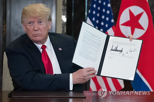 북미정상회담 공동합의문 들어보이는 트럼프 (싱가포르 AFP=연합뉴스) 역사적 첫 북미정상회담이 열린 12일(현지시간) 싱가포르 센토사 섬 카펠라호텔에서 도널드 트럼프 미국 대통령이 자신과 김정은 북한 국무위원장이 서명한 공동합의문을 들어 보이고 있다.