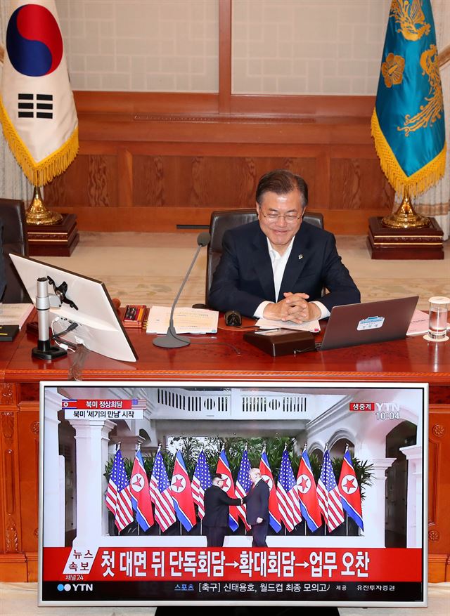 문재인 대통령이 12일 오전 청와대 세종실에서 국무회의를 시작하기에 앞서 싱가포르 북-미 정상회담에서 김정은 국무위원장과 도널드 트럼프 미국 대통령이 만나 악수하는 장면의 생중계 화면을 지켜보고 있다. 고영권 기자