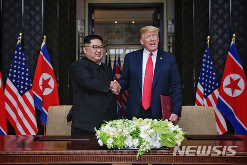 【서울=뉴시스】 12일 김정은 북한 국무위원장과 도널드 트럼프 미국 대통령이 싱가포르 센토사섬 카펠라 호텔에서 북미정상회담 합의문에 서명한 뒤에 악수를 하고 있다. 2018.06.12.  (사진=싱가포르 통신정보부 제공)photo@newsis.com