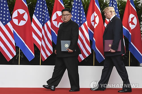 공동합의문 들고 함께 걸어가는 북미정상 (싱가포르 AP=연합뉴스) 역사적 첫 북미정상회담이 열린 12일(현지시간) 싱가포르 센토사 섬 카펠라호텔에서 미국 도널드 트럼프 대통령(오른쪽)과 북한 김정은 국무위원장이 공동으로 서명을 마친 합의문을 들고 나란히 걸어가고 있다.      lkm@yna.co.kr