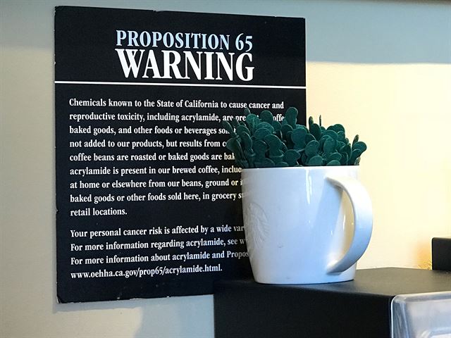 지난 3월 30일 미국 캘리포니아주 버뱅크시의 한 스타벅스 매장에 커피에 함유된 발암물질의 위험성을 알리는 경고문이 벽에 게시돼 있다. AP 연합뉴스 자료사진