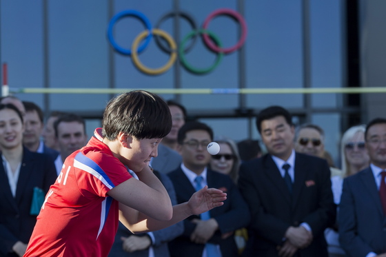 23일 스위스 로잔에서 열린 IOC 올림픽데이 행사에 북한의 김송이가 서브를 시도하고 있다. 오른쪽은 북한 김일국 체육상. [EPA=연합뉴스]