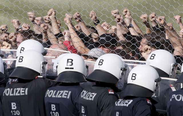 슬로베니아와의 접경지역에 있는 오스트리아 슈필펠트에서 26일(현지시간)  국경 방어 훈련 중인 오스트리아 경찰들이 철조망 뒤에 서 있다. 차기 EU 의장국인 오스트리아는 강경한 반난민 정책을 펼치고 있다. AP 연합뉴스