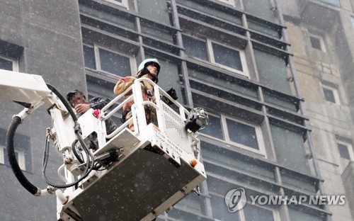 구조되는 근로자  (세종=연합뉴스) 이진욱 기자 = 26일 오후 세종시 새롬동 신도심 한 아파트 건설현장에서 화재가 발생, 갇혀있던 건설현장 근로자가 구조되고 있다. 2018.6.26