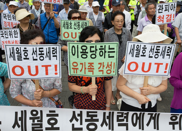 탈북난민인권엽합과 나라사랑실천운동과 남침용땅굴을찾는사람들 그리고 대한민국어버이연합 등 시민·사회단체 회원들이 2014년 8월 21일 오후 서울 종로구 청운효자동주민센터 앞에서 열린 '박근혜 대통령의 책임이행을 촉구하는 각계 대표 170인 기자회견' 앞에서 맞불 반대집회를 열고 있다. 맞불집회에 참가한 회원들은 이날 세월호 유가족이 선동세력에 의해 조종당하고 있다고 주장하며 이로인해 나라경제가 나락으로 떨어지고 있다고 주장했다. 또 세월호 사고는 해상교통사고에 불과하다며 단순 사고로 폄하하기도 했다. 김성광 기자 flysg2@hani.co.kr