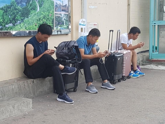3일 오후 전남 영광군 시외버스터미널에 중국인 3명이 쪼그리고 앉아 휴대폰을 들여다보고 있다. 한 중국인은 “일자리를 소개해준다는 친구 말을 듣고 여기 왔다”고 했다./김명진 기자