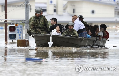 "이제 안심" (오카야마 교도=연합뉴스) 폭우로 물에 잠긴 일본 오카야마(岡山)현 구라시키(倉敷)시 마비초(眞備町) 마을에서 자위대원이 보트를 통해 고립된 주민들을 구조하고 있다. 2018.7.7    choinal@yna.co.kr