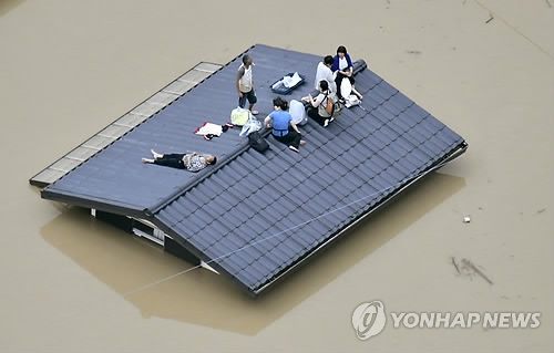 오카야마현 구사시키의 주택가에서 고립된 주민들이 한 가옥의 지붕에 올라가 구조를 기다리는 모습. [AP=연합뉴스 자료사진]