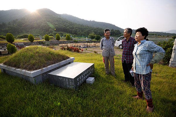 ⓒ시사IN 조남진 고모(오른쪽)·고모부(왼쪽)와 함께 어머니 산소를 찾은 박씨. 4년형을 살고 나와 절에 들어간 박씨의 어머니는 재심 판결을 받은 다음 해 생을 마감했다.