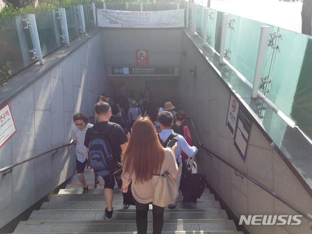 【서울=뉴시스】 류병화 기자 = 동대문역사문화공원역 환승통로 폐쇄 첫 날인 18일 오전 5번출구 외부 통로를 이용해 환승하는 시민들. 2018.07.18. hwahwa@newsis.com