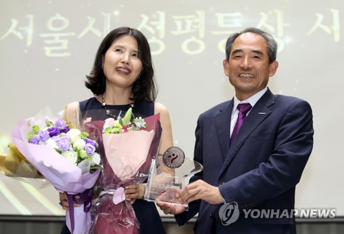 '미투운동 확산' 최영미 시인, 서울시 성평등상 수상 (서울=연합뉴스) 임헌정 기자 = '미투운동' 확산에 기여한 공로로 서울시 성평등상 대상 수상자로 선정된 최영미 시인이 3일 오후 서울시청에서 열린 시상식에서 윤준병 서울시 행정1부시장으로부터 상패를 받은 뒤 기념촬영하고 있다. 2018.7.3      kane@yna.co.kr
