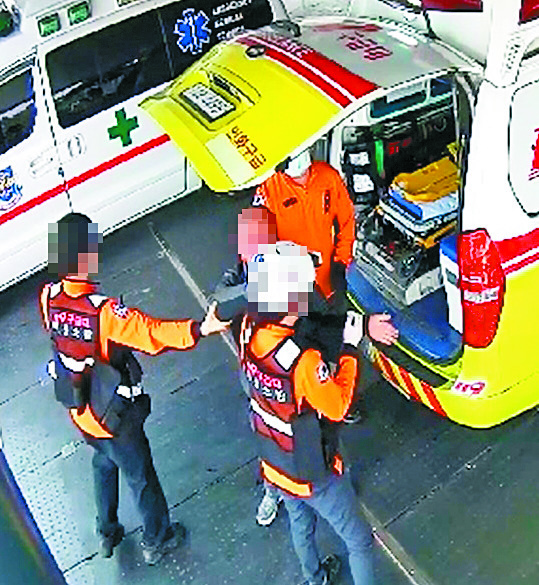 지난 4월 2일 전북 익산시 원광대병원 응급실 앞에서 윤모(48)씨가 자신을 구해준 구급대원 강연희(51·여) 소방경의 머리를 때리는 모습이 담긴 CCTV 영상 캡처. [사진 전북소방본부]