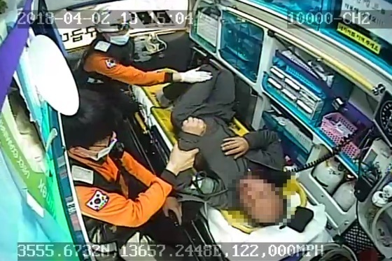 지난 4월 2일 전북 익산소방서 인화119안전센터 소속 119구급차 내부 CCTV 영상 캡처. 이날 익산역 앞 도로에서 술 취해 쓰러진 윤모(48)씨가 그를 구조한 구급대원 박모(33·소방사)씨를 손바닥으로 때리고 있다. 뒤쪽에서 강연희(51) 소방경이 말리고 있다. [사진 전북소방본부]
