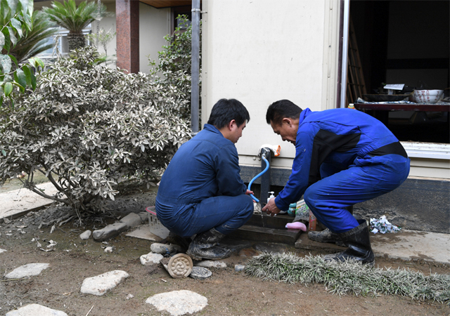 서일본 폭우로 침수됐던 니시하라 부부의 집을 정리하고 있는 차남(오른쪽)과 손자. 아사히신문 제공