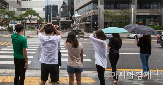 수도권을 중심으로 거센 소나기가 예보된 9일 서울 강남구 테헤란로에서 시민들이 소나기를 맞으며 보행신호를 기다리고 있다./강진형 기자aymsdream@